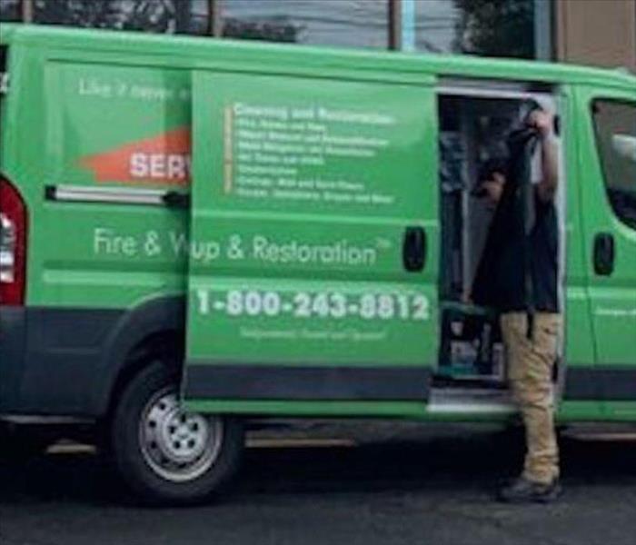 A SERVPRO employee in the back of a SERVPRO van.